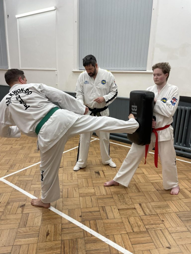 Mr Anthony Harris teaching green belt how to side kick