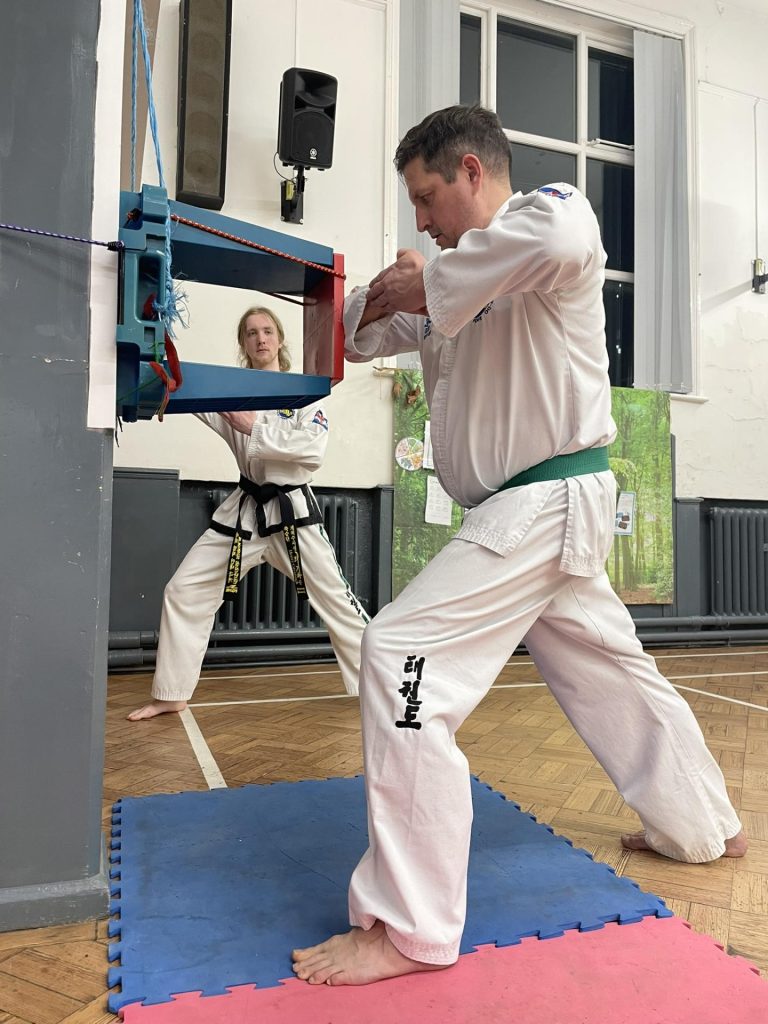 Photo of Henry Cavanagh teaching a green belt how to elbow strike